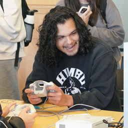 student laughs while playing a video game 